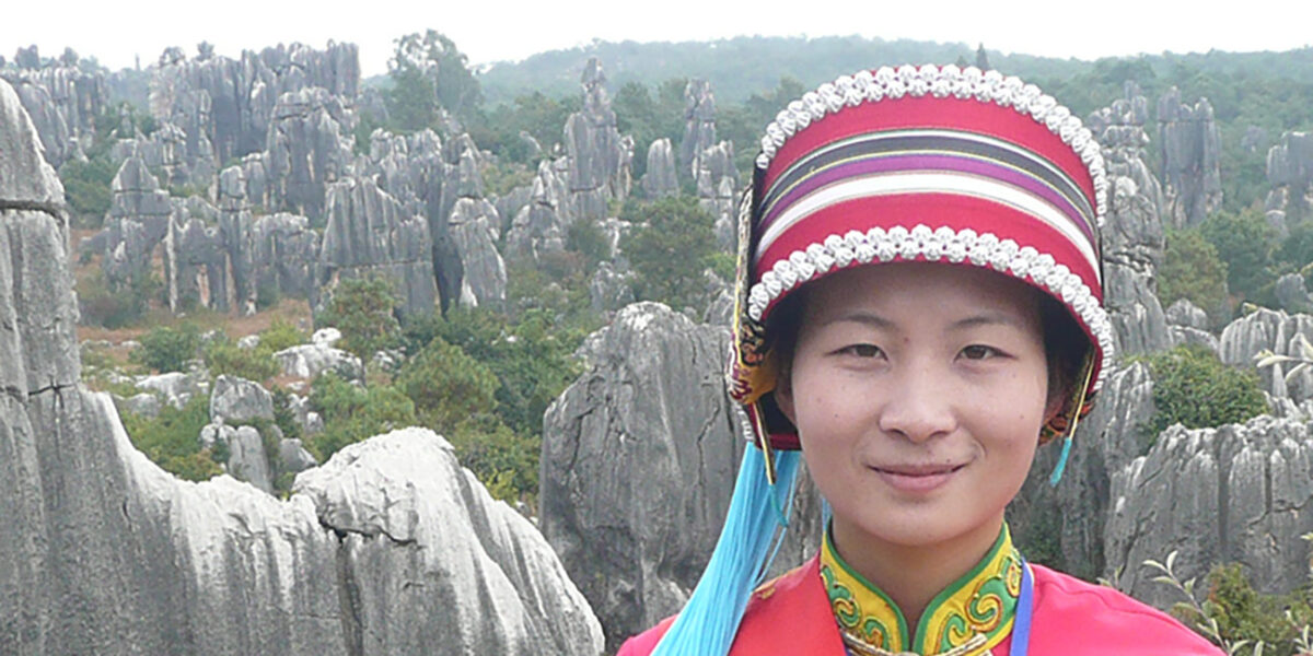 Mujer con el traje tradicional de la etnia Yi en el bosque de piedra de Shilin. Foto: Brücke-Osteuropa, dominio público. Wikimedia para «People of shinin».