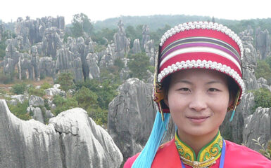 Mujer con el traje tradicional de la etnia Yi en el bosque de piedra de Shilin. Foto: Brücke-Osteuropa, dominio público. Wikimedia para «People of shinin».