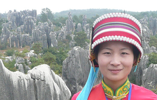 Mujer con el traje tradicional de la etnia Yi en el bosque de piedra de Shilin. Foto: Brücke-Osteuropa, dominio público. Wikimedia para «People of shinin».