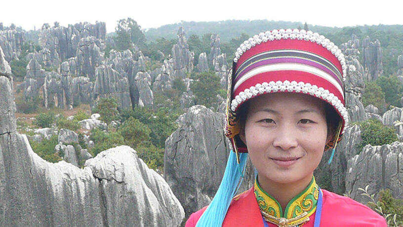 Mujer con el traje tradicional de la etnia Yi en el bosque de piedra de Shilin. Foto: Brücke-Osteuropa, dominio público. Wikimedia para «People of shinin».