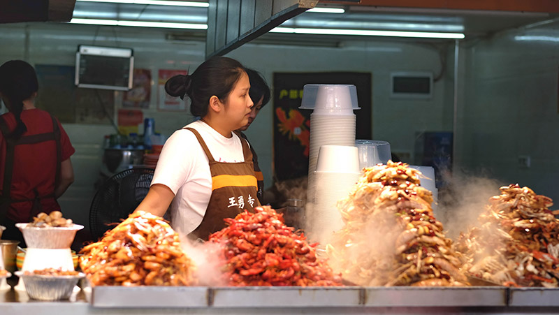 Una de las vendedoras de comida callejera en el callejón Hubu. Foto: 123RF.