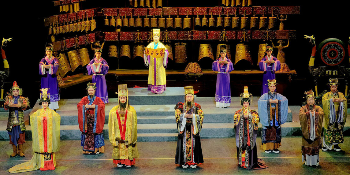 Ópera de Tambor de Flores 'Los Ecos Dorados de Sui'. Teatro de Arte de Ópera de Tambor de Flores de Suizhou. Las campanas son fundidas. El sumo sacerdote invoca la armonía entre los reinos, y el Rey de Zhou emite un decreto de honor. Foto: Uuongkinghe, CC BY-SA 4.0, Wikimedia para «Flower Drum Opera»