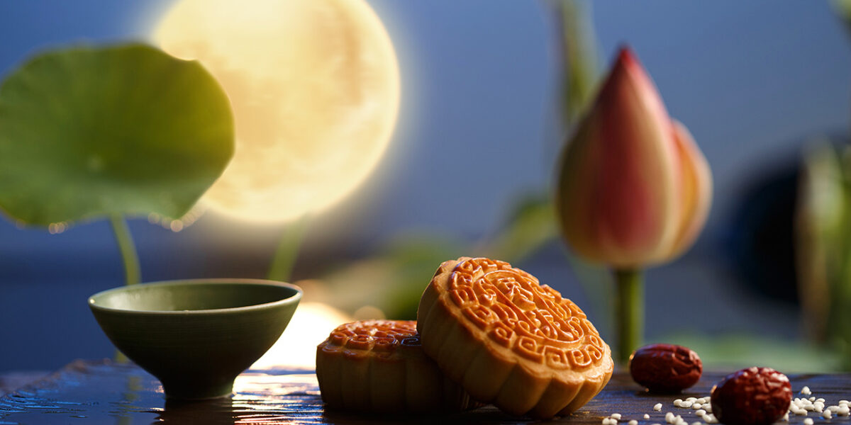 Pasteles de la luna en la fiesta del medio otoño, con la luna llena al fondo.