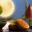 Pasteles de la luna en la fiesta del medio otoño, con la luna llena al fondo.