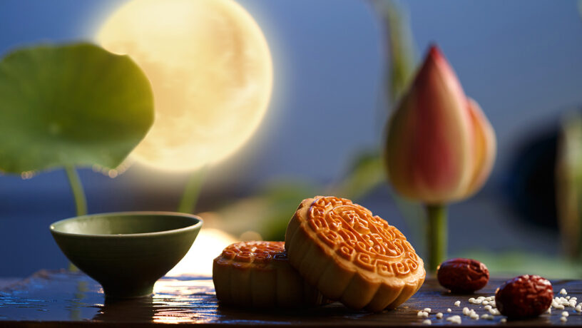 Pasteles de la luna en la fiesta del medio otoño, con la luna llena al fondo.