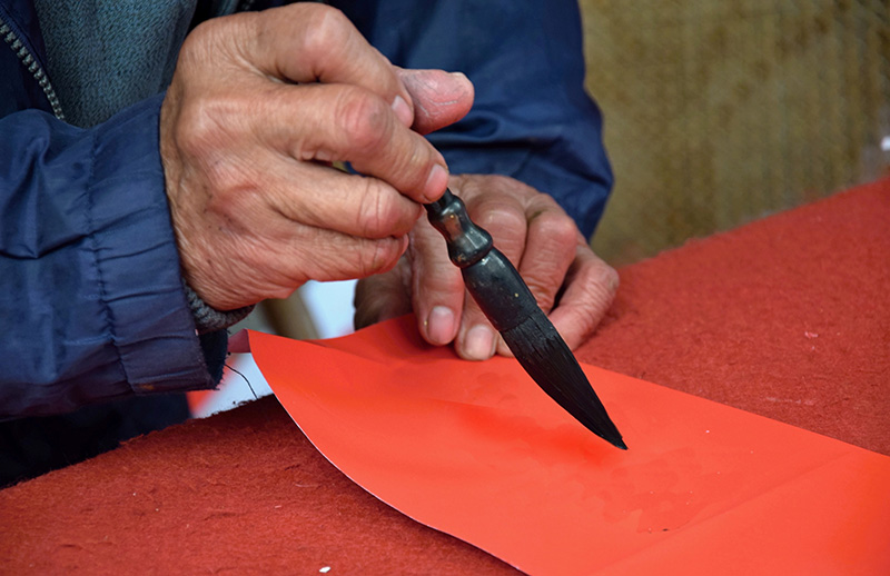 Para escribir los pareados chun lian es muy apreciado usar técnicas caligráficas. Tinta negra o dorada sobre papel rojo. Foto: 123RF.